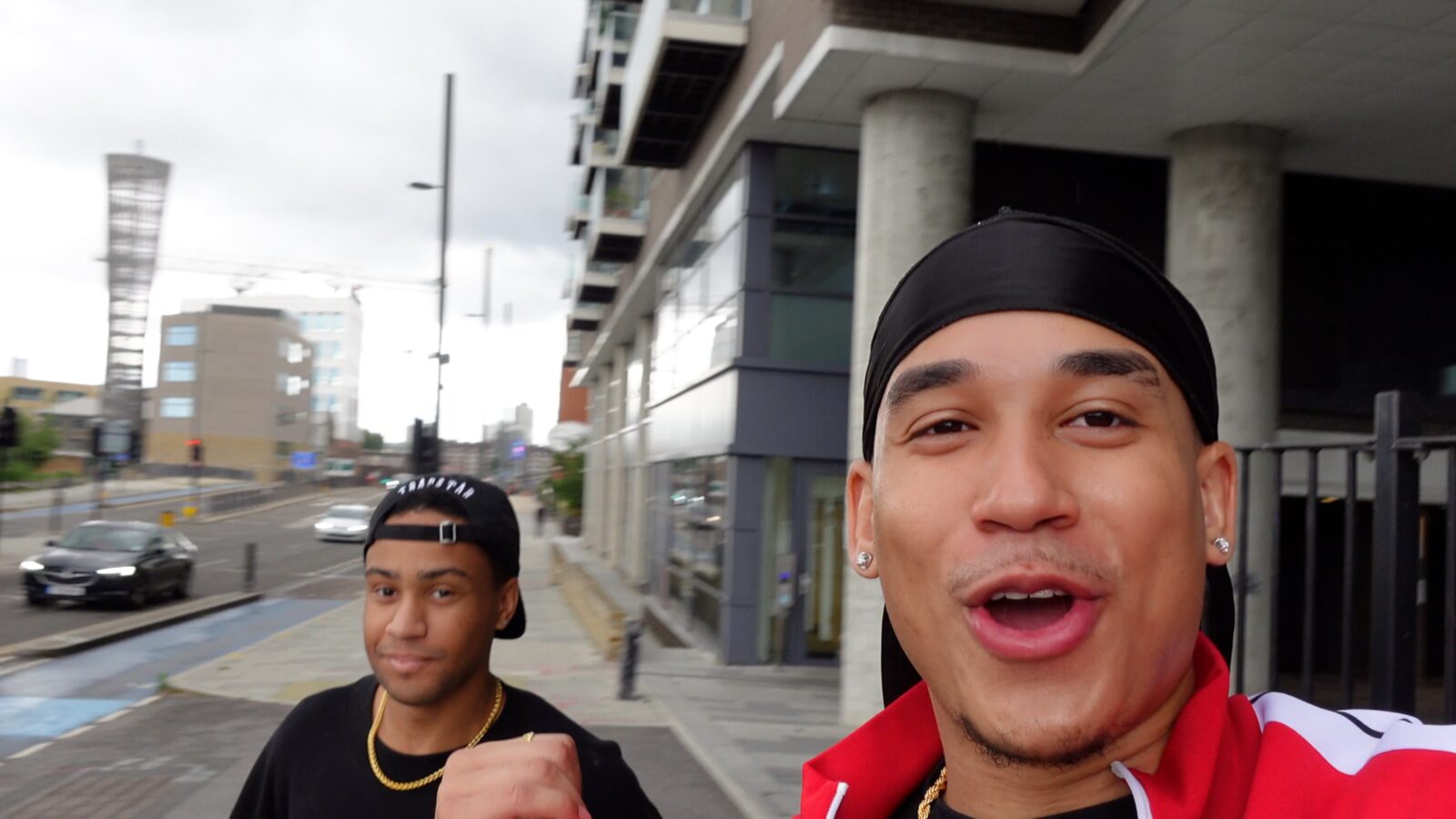 Joshua Arthur vlogging on a London street, a friend walking behind him