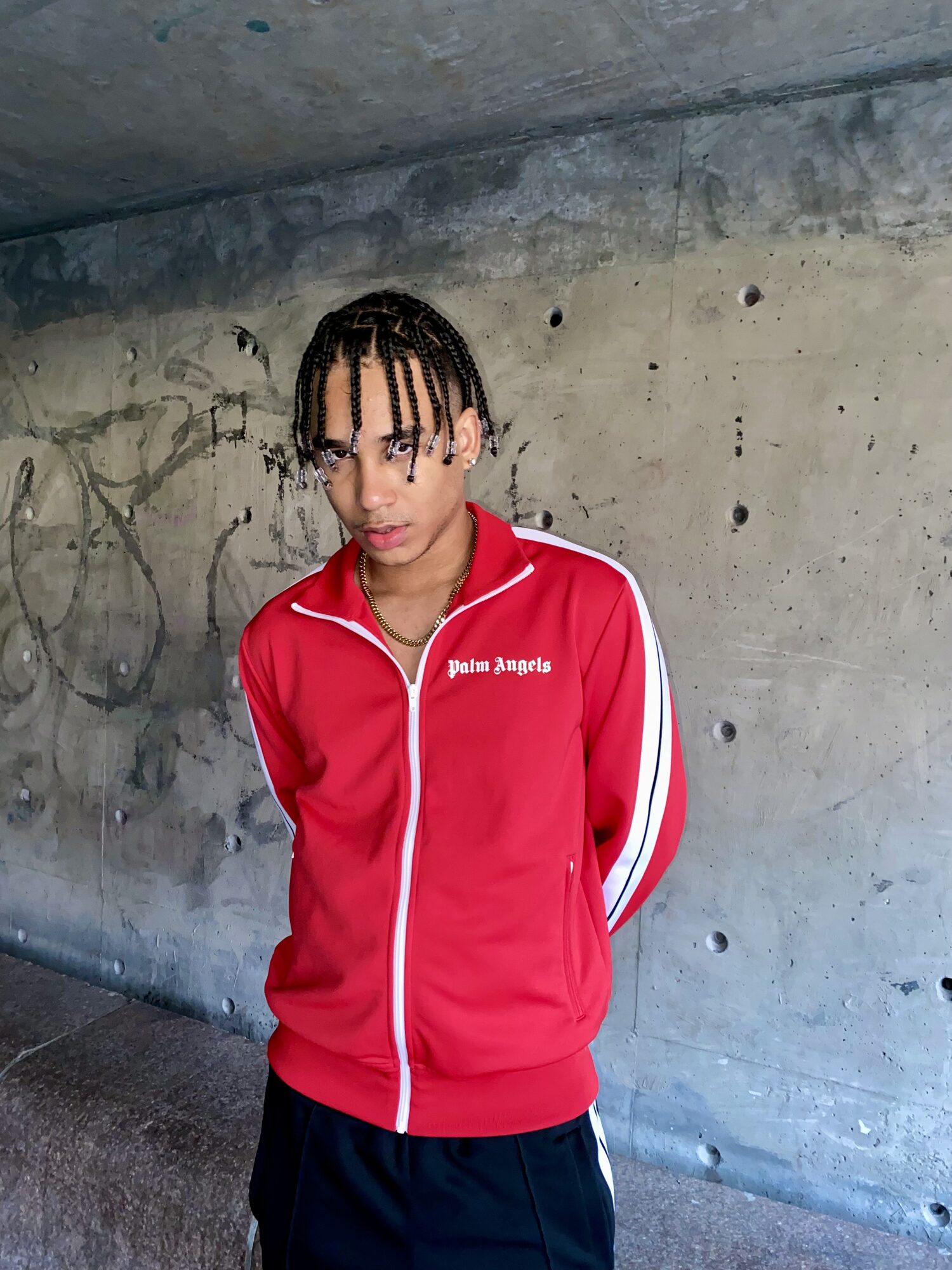 Joshua Arthur (JJDREAMSS) · 2021 — Box braids instead of the usual curls, red Palm Angels on a running track