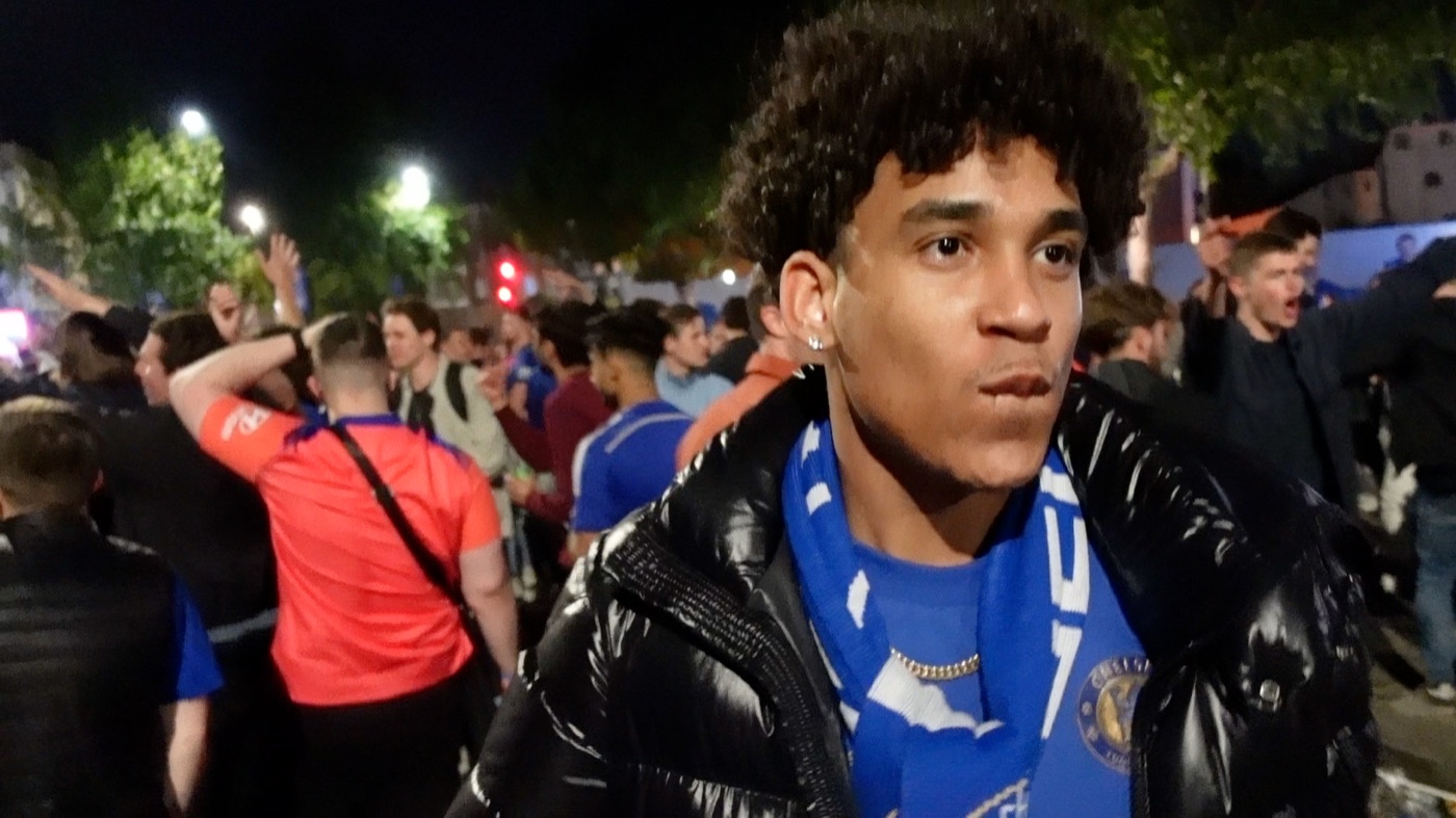 Joshua Arthur in a football crowd at night wearing a club scarf, from the documentary Am I Really Free?