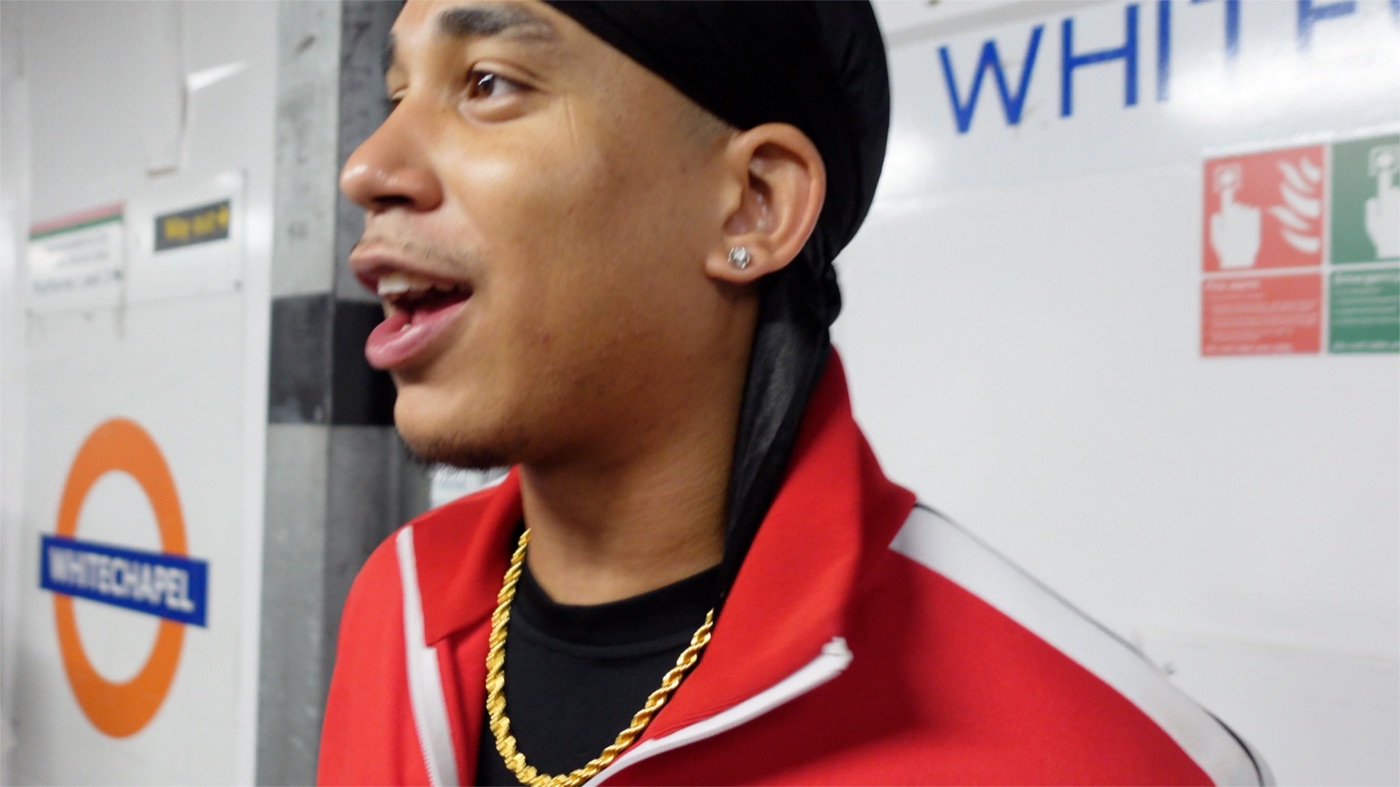 Joshua Arthur speaking to camera on the platform at Whitechapel Underground station, from the documentary Am I Really Free?