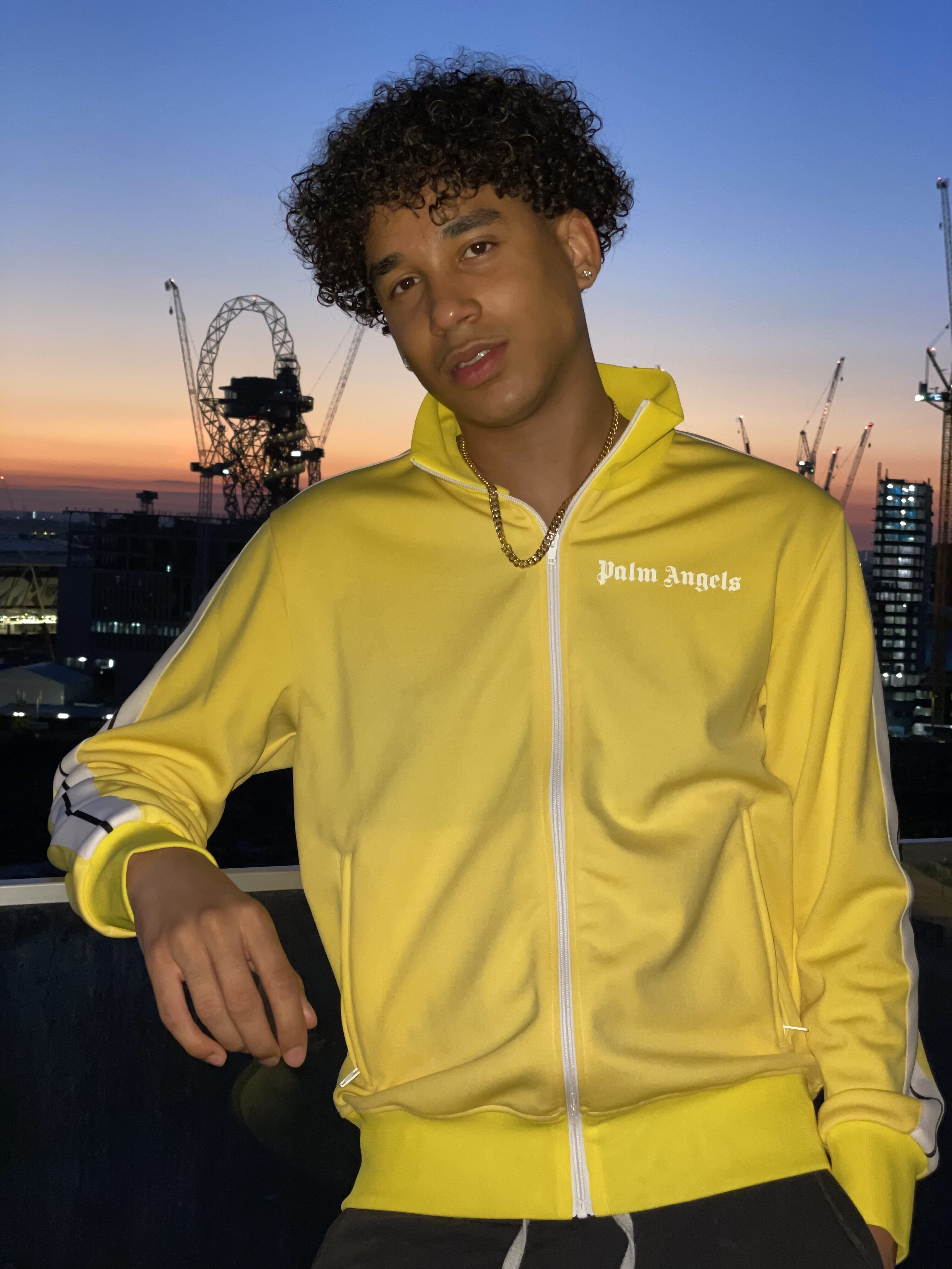 Joshua Arthur (JJDREAMSS) · London — Bright yellow Palm Angels on the balcony over the Olympic Park at Stratford